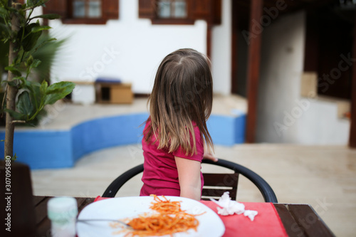 Photography child turns away from plate with pasta