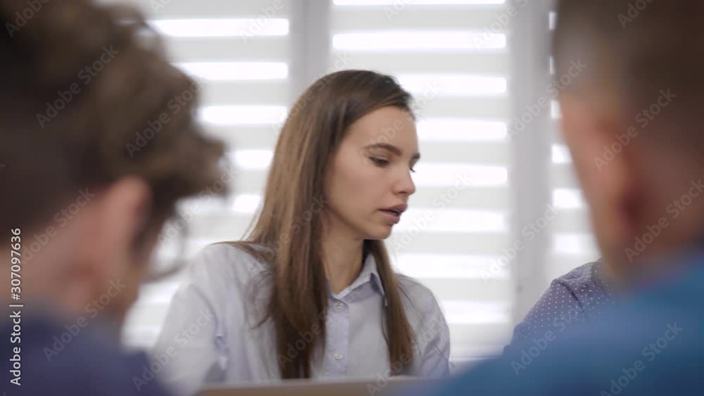 young woman is talking with her colleagues men at business meeting in office, explaining and discussing young woman is talking with her colleagues men at business meeting in office, explaining and discussing