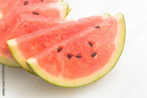 Cut watermelon into cubes and place on a white background