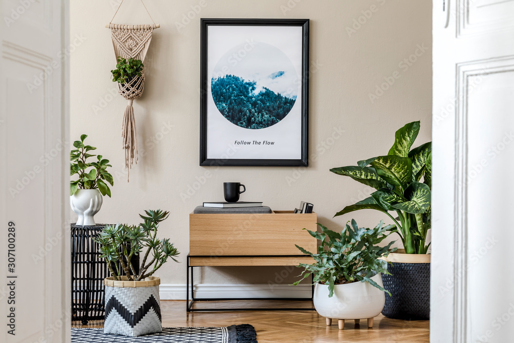 Modern scandinavian living room interior with black mock up poster frame, design commode, a lot of plants in different pots, macrame and elegant accessories. Template. Stylish home decor.  - obrazy, fototapety, plakaty 