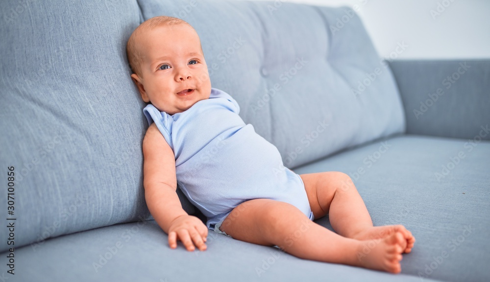 Adorable baby lying down on the sofa at home. Newborn relaxing and resting comfortable Adorable baby lying down on the sofa at home. Newborn relaxing and resting comfortable