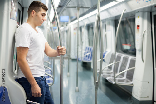 Man in white shirt traveling on subway