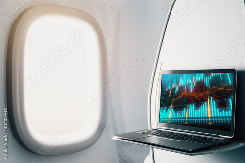 Laptop closeup inside airplane with forex graph on screen. Financial market trading concept. 3d rendering.