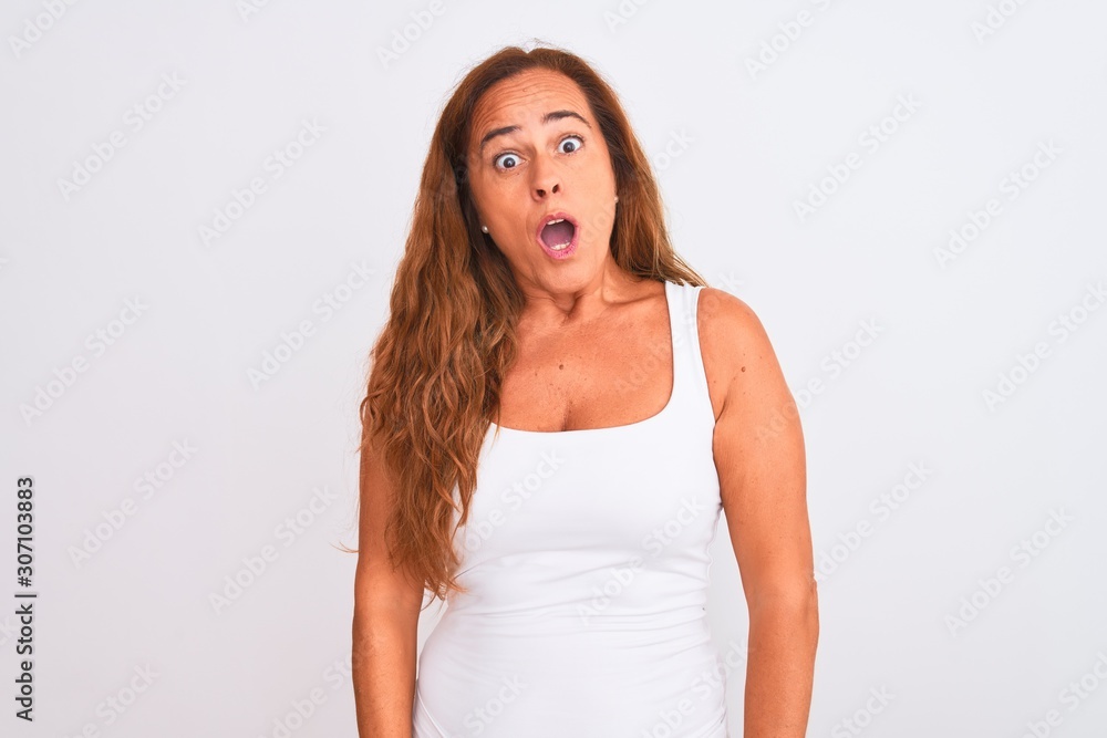 Middle age mature woman standing over white isolated background In shock face, looking skeptical and sarcastic, surprised with open mouth Middle age mature woman standing over white isolated background In shock face, looking skeptical and sarcastic, surprised with open mouth