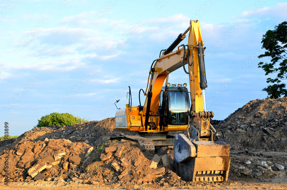 Obraz premium Excavator with crusher bucket for crushing concrete. Construction waste recycling for construction mix. Sifting and grinding bucket for the separation of concrete into fractions of higher quality.