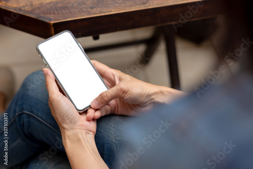 Mockup image blank white screen cell phone.men hand holding texting using mobile on desk at home office. background empty space for advertise text.people contact marketing business and technology 
