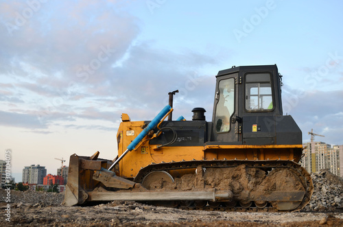 Track-type bulldozer, earth-moving equipment. Land clearing, grading, pool excavation, utility trenching, utility trenching and foundation digging during of large construction jobs. © MaxSafaniuk