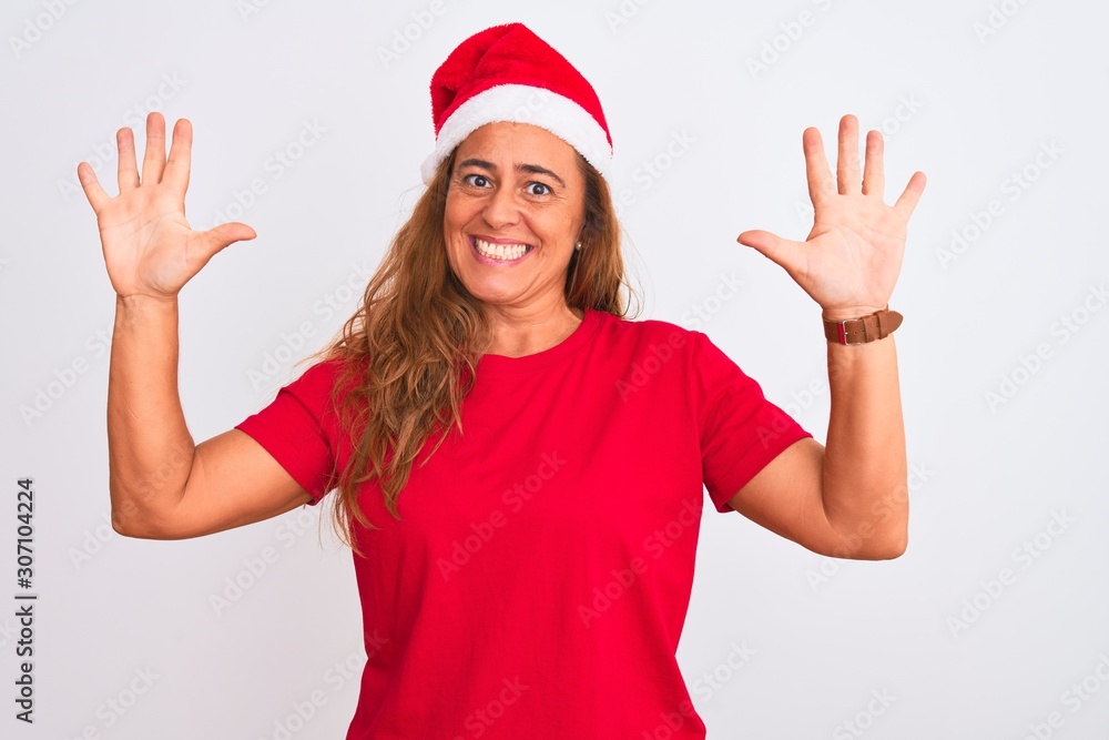 Middle age mature woman wearing christmas hat over isolated background showing and pointing up with fingers number ten while smiling confident and happy. Middle age mature woman wearing christmas hat over isolated background showing and pointing up with fingers number ten while smiling confident and happy.