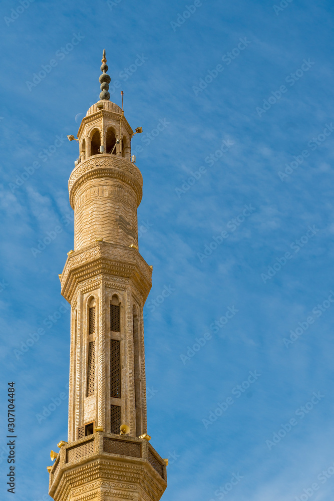 Minaret on a background of blue sky. Islamic faith concept. vertical photo
