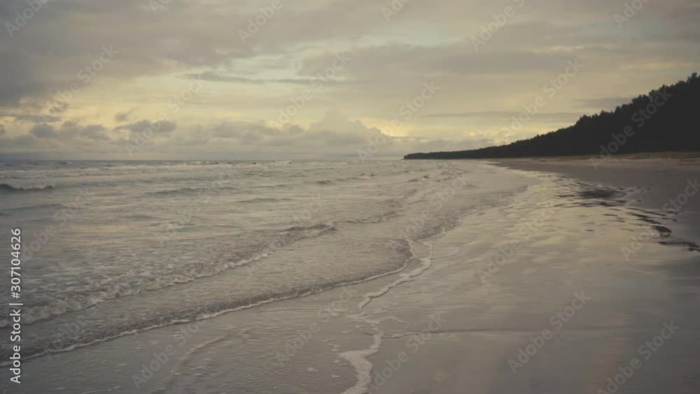 Sea waves rhythmically run onto the sandy beach of the Baltic Sea in summer. Some are more fortunate Sea waves rhythmically run onto the sandy beach of the Baltic Sea in summer. Some are more fortunate