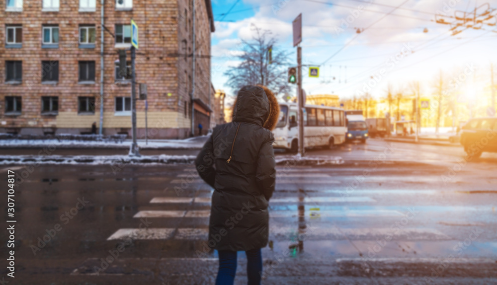 Girl Crosses The Road At The Green Light Of a Traffic Light At a Pedestrian Crossing In Winter