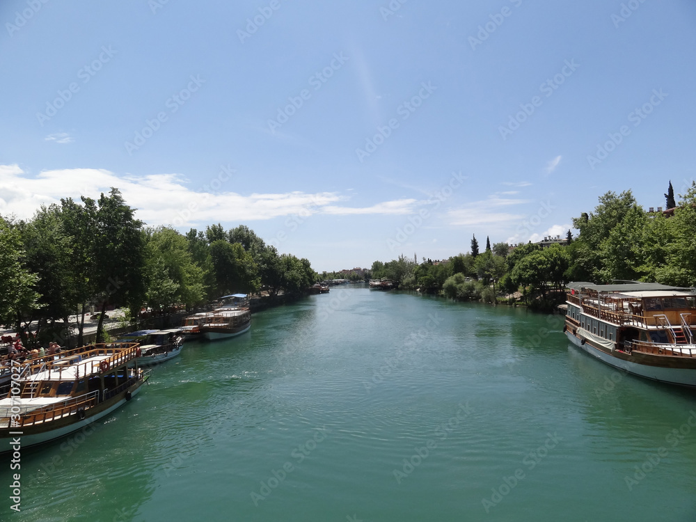 Fototapeta premium One of the tourist cities of Turkey. View from the bridge to the river and the ships that stand at the berths