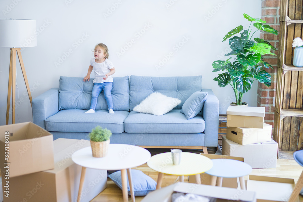 Beautiful toddler child girl jumping on the sofa