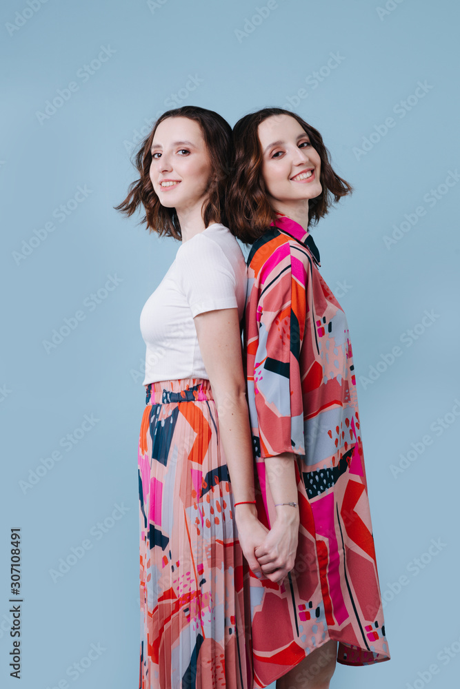 Two twin sister in a bright image on a blue background