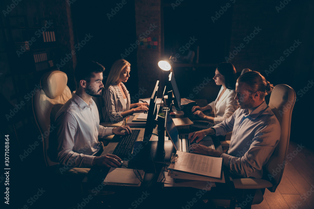 Profile side view of four nice attractive skilled experienced hardworking guys sharks marketers businesspeople working at night preparing finance report at workplace station indoors