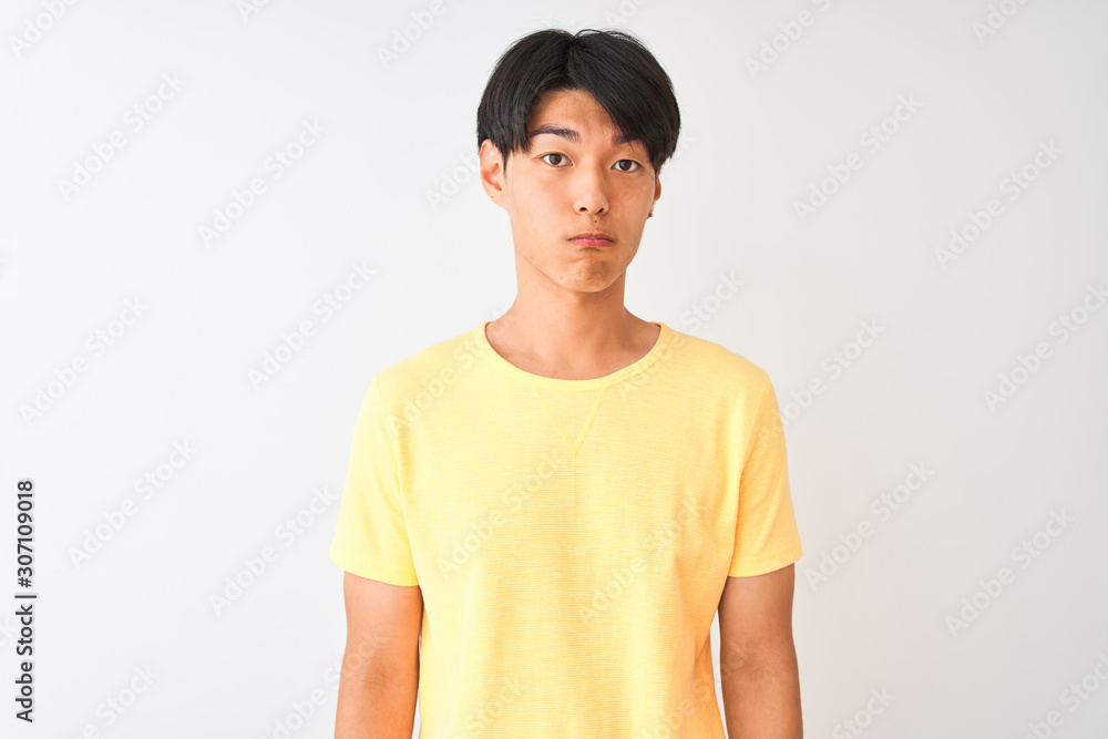 Chinese man wearing yellow casual t-shirt standing over isolated white background depressed and worry for distress, crying angry and afraid. Sad expression. Chinese man wearing yellow casual t-shirt standing over isolated white background depressed and worry for distress, crying angry and afraid. Sad expression.