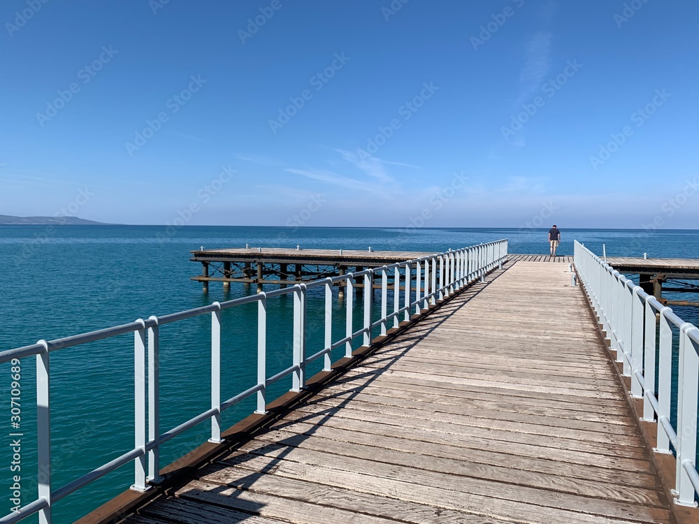 Wooden jetty over the beautiful mediterranean sea with blue sky