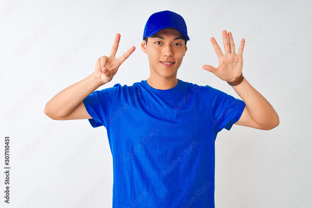 Chinese deliveryman wearing blue t-shirt and cap standing over isolated white background showing and pointing up with fingers number seven while smiling confident and happy. Chinese deliveryman wearing blue t-shirt and cap standing over isolated white background showing and pointing up with fingers number seven while smiling confident and happy.