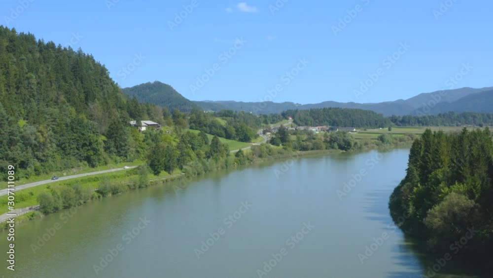 Traffic road and cars passing by the river surrounded with green trees and mountains. Aerial footage Traffic road and cars passing by the river surrounded with green trees and mountains. Aerial footage