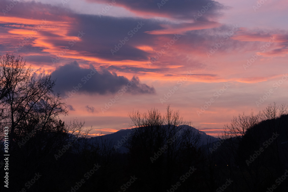 Dramatic sunset with pink clouds over bar trees and hills in wintertime in Switzerland. Unprocessed and original. Dramatic sunset with pink clouds over bar trees and hills in wintertime in Switzerland. Unprocessed and original.