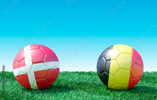 Two soccer balls in flags colors on green grass. Denmark and Belgium. 3d image