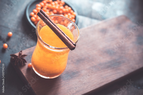 Autumn or winter sea buckthorn drink. Sea Buckthorn tea, selective focus. Still life, food and drink, seasonal and holidays concept. Autumn hot beverage in a glass