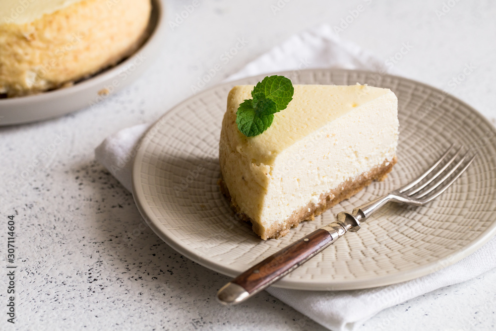 Slice Of Classical New York Cheesecake On White Plate. Closeup View. Home bakery concept Slice Of Classical New York Cheesecake On White Plate. Closeup View. Home bakery concept