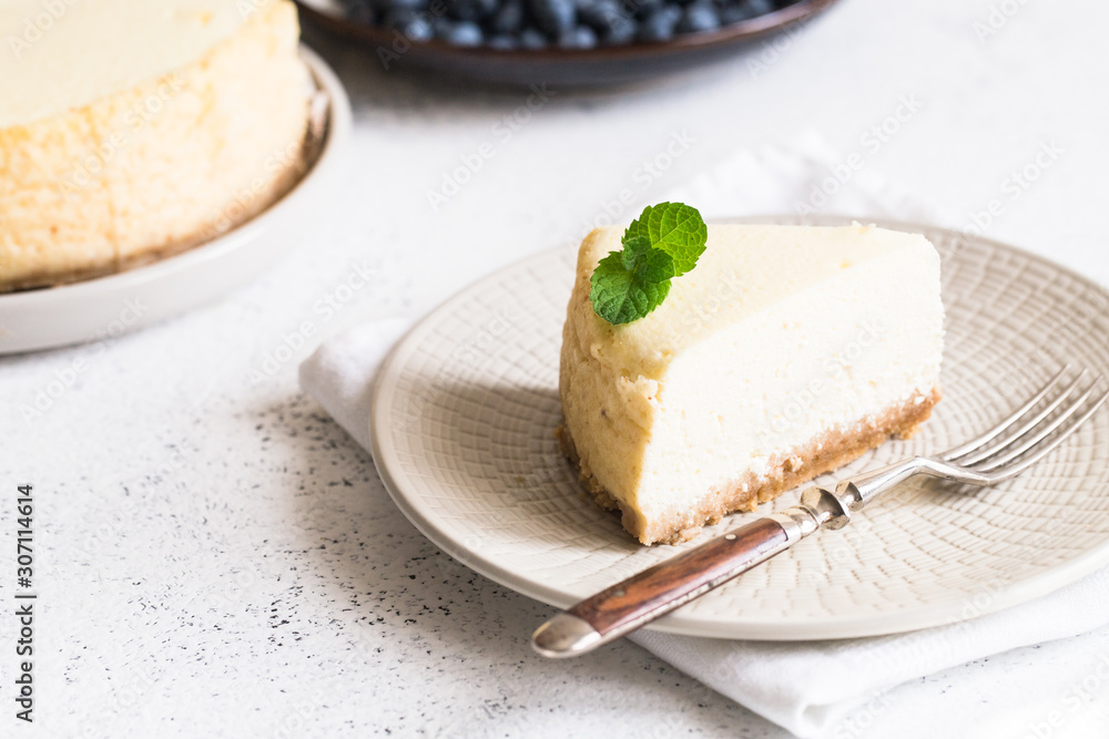 Slice Of Classical New York Cheesecake On White Plate. Closeup View. Home bakery concept Slice Of Classical New York Cheesecake On White Plate. Closeup View. Home bakery concept