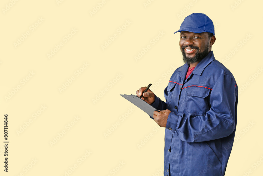 African-American car mechanic on color background African-American car mechanic on color background