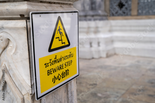 Sign at the Grand Palace Bangkok Thailand - English translation from Thai - Beware Step - tells visitors to watch their step