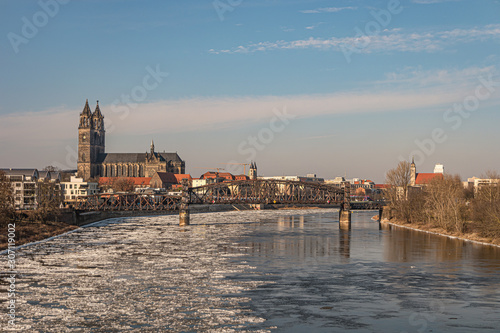 Stunning sunset over Magdeburg downtown in Winter with ice drift in Elbe river, Germany, sunny day, blue clean sky
