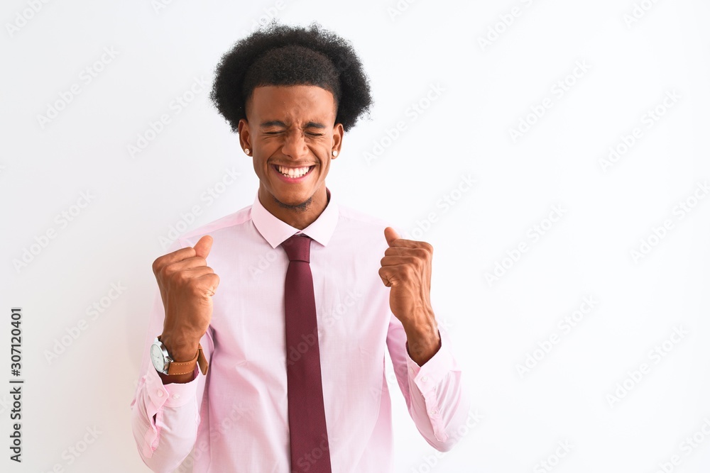Young african american businessman wearing tie standing over isolated white background excited for success with arms raised and eyes closed celebrating victory smiling. Winner concept. Young african american businessman wearing tie standing over isolated white background excited for success with arms raised and eyes closed celebrating victory smiling. Winner concept.