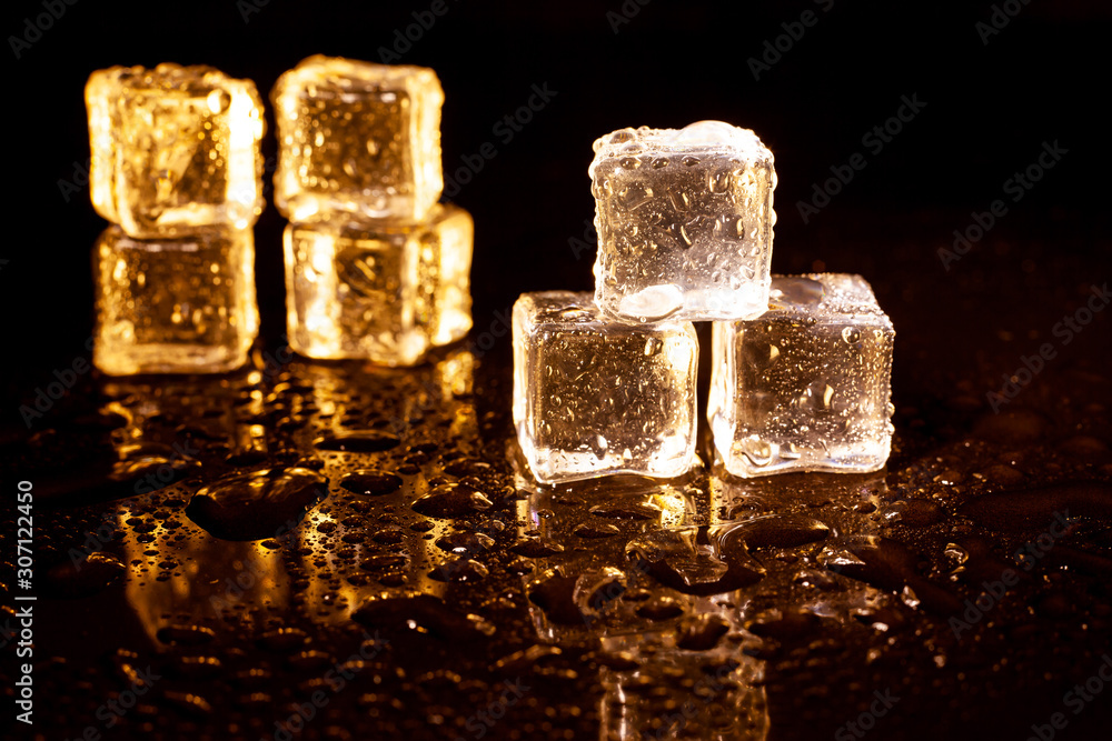 Golden ice cubes on black background. Golden ice cubes on black background.