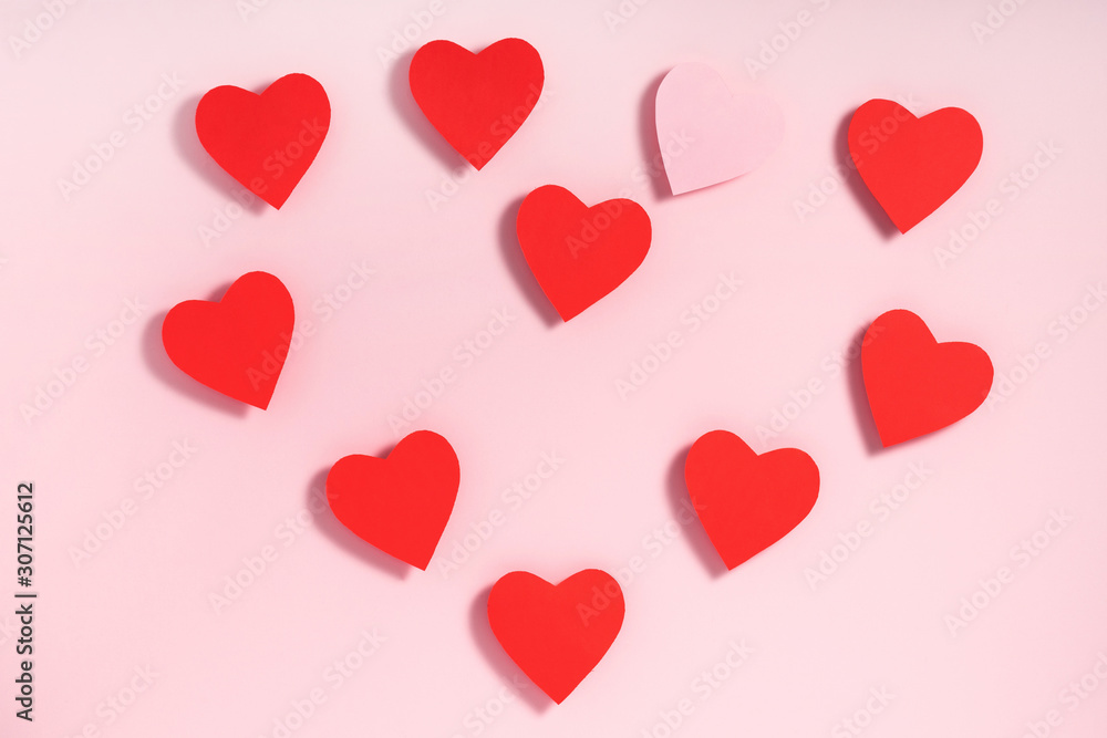 Valentine's day composition. Heart shape made of paper hearts on pink paper background. Valentine's day concept