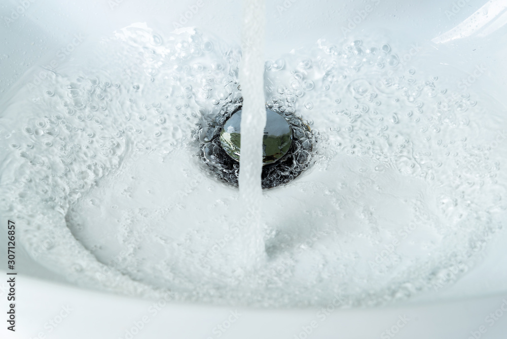 Water flows from the faucet into the sink. Concept saving water. Water flows from the faucet into the sink. Concept saving water.