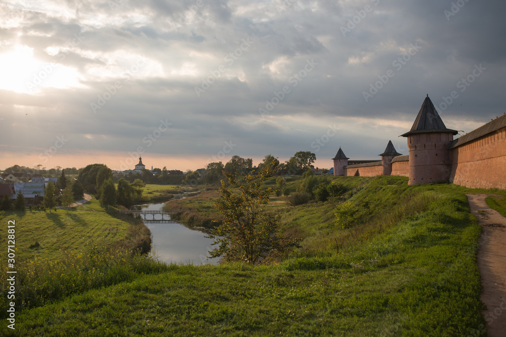 Fototapeta premium Letni ciepły wieczór w Suzdal. Rosyjski krajobraz ze świątynią i rzeką
