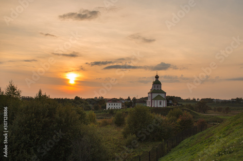 Russian Orthodox Church in Suzdal. landscape with a temple at sunset on a warm summer evening in a field with green uncut grass