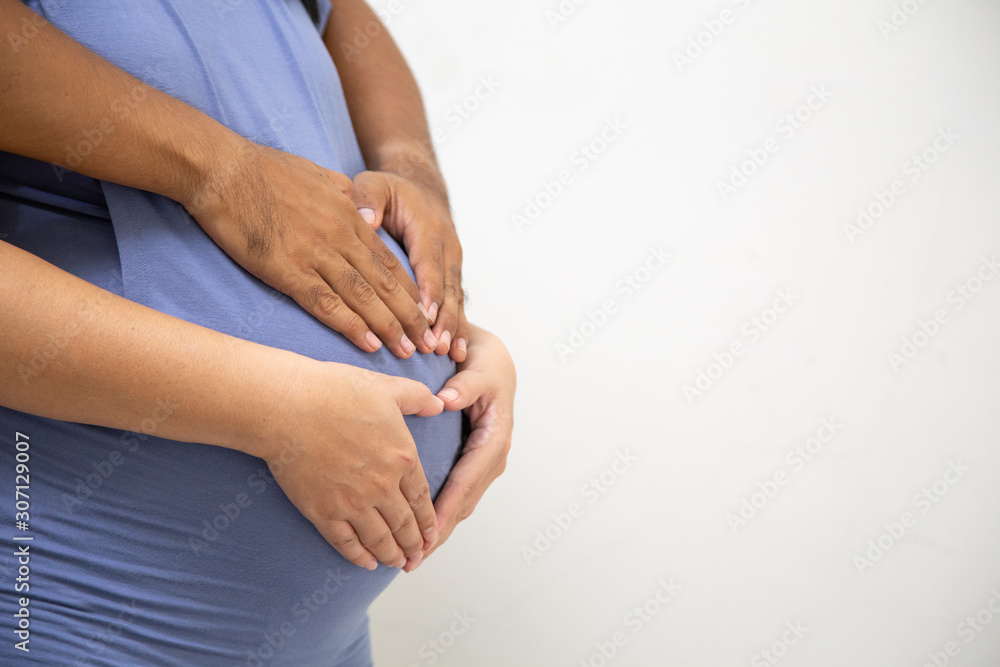 Husband and wife hands touching the belly of the pregnancy, Pregnant women the abdomen with tenderness, Concept: Family expectations Happy lifestyle,