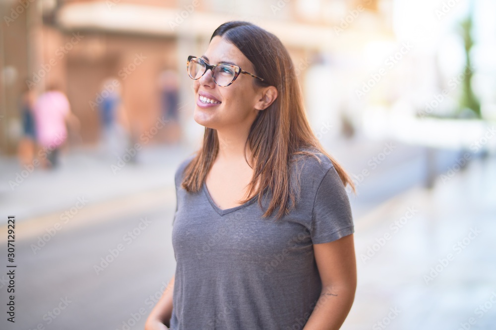 Young beautiful woman smiling happy and confident. Standing with smile on face at town street