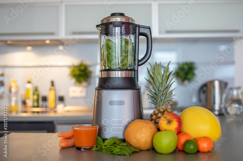 Photos Making green smoothies with blender in home kitchen, healthy eating lifestyle co