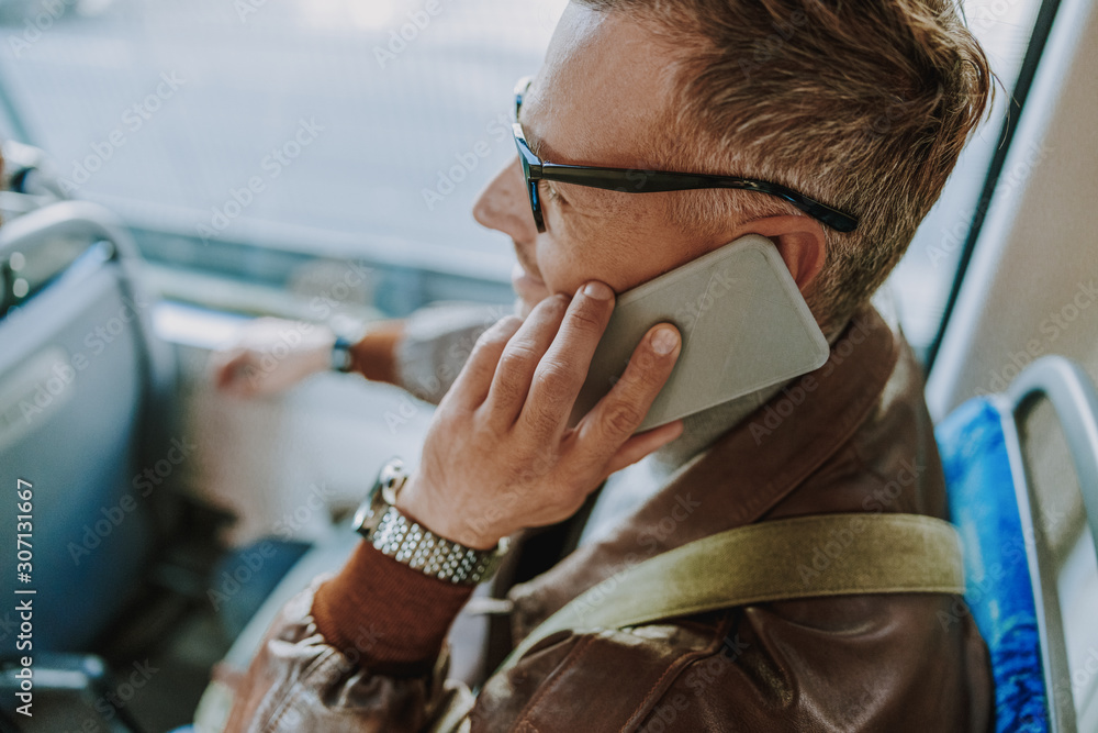 Handsome man talking on cellphone in public transport Handsome man talking on cellphone in public transport