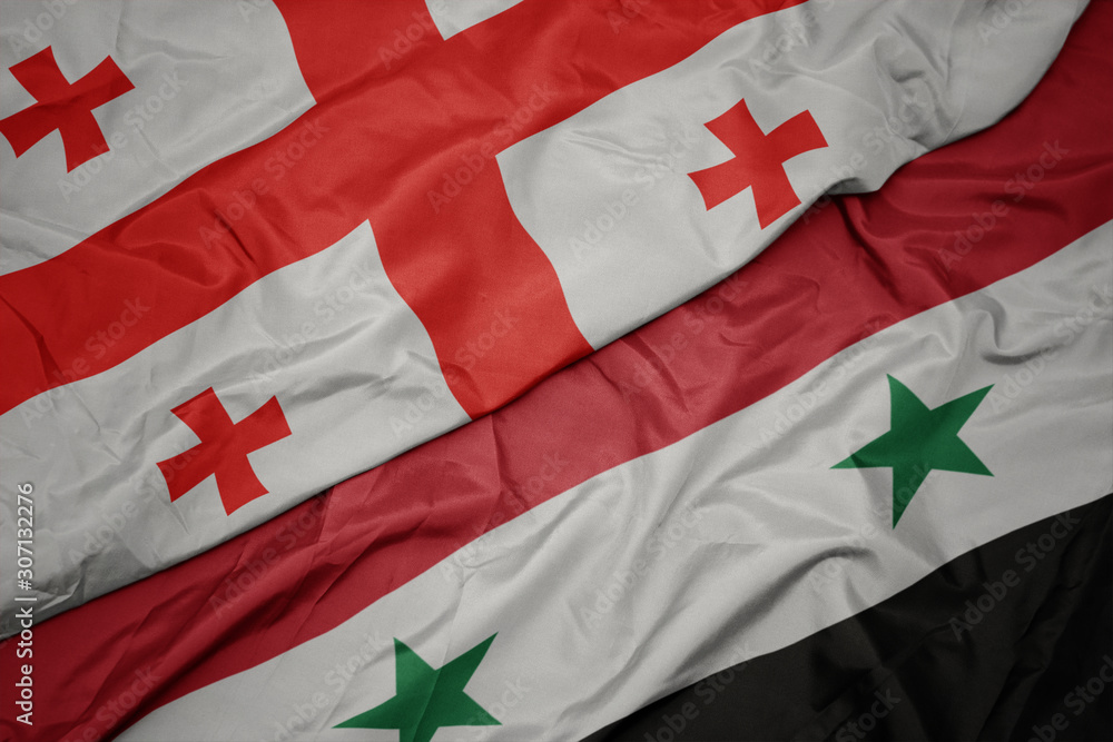 Fototapeta premium waving colorful flag of syria and national flag of georgia.