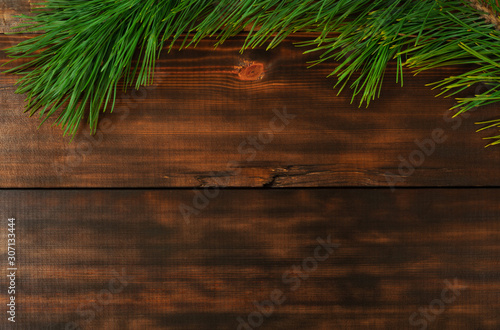 Christmas tree branch on wooden table. Christmas, New Year and Winter holiday concept photo.