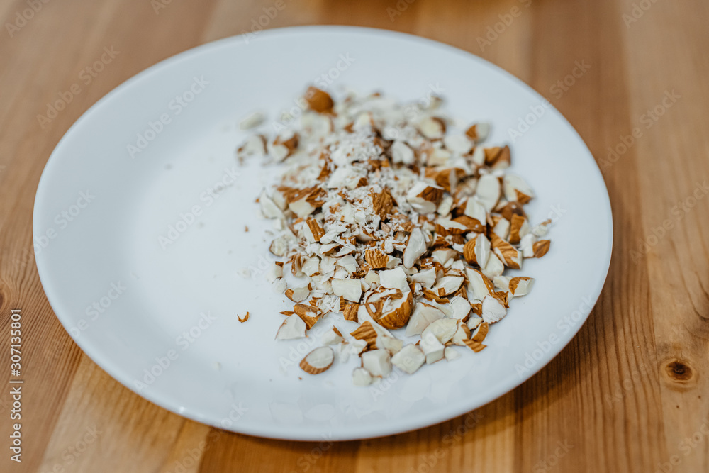 Large white plate with coarsely chopped nuts Large white plate with coarsely chopped nuts