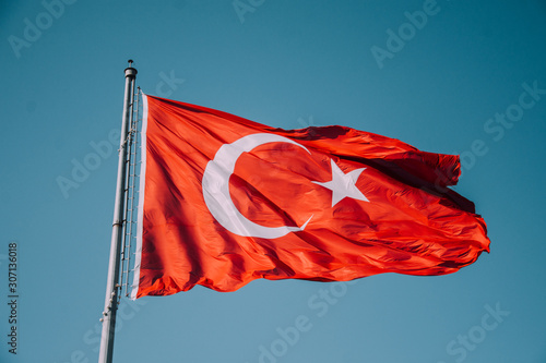 Turkish flag on sky background. Waving red flag. Turkish patriotism. Turkey Day. Cumhuriyet Bayramı. Izmir, Turkey. National Turkish flag.