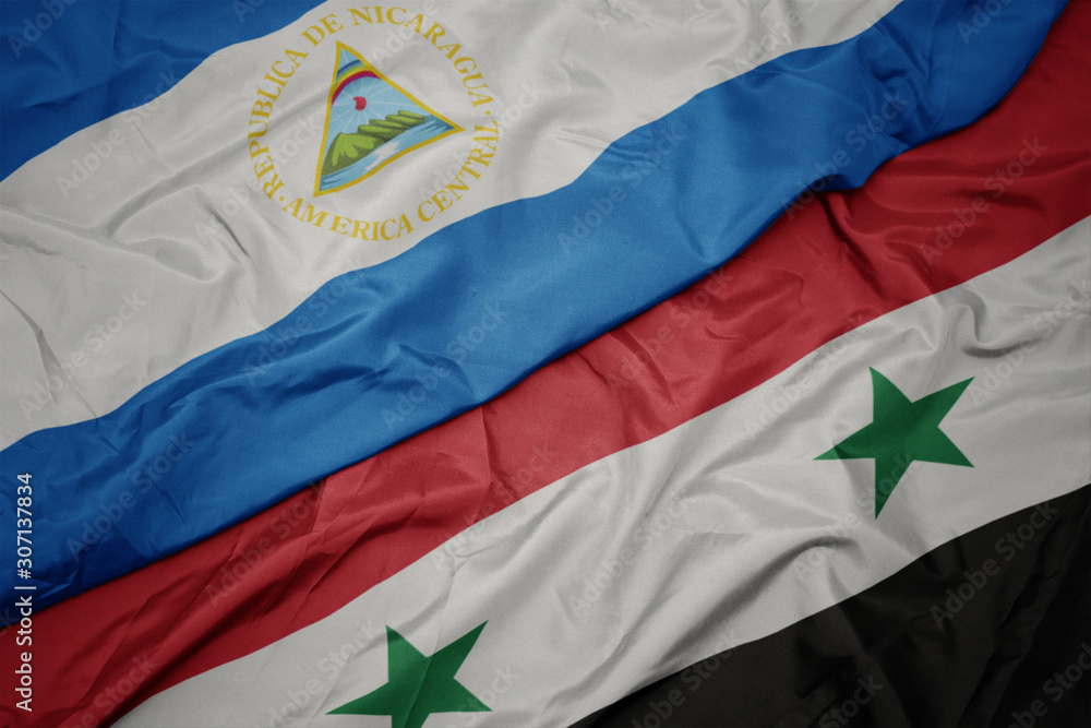 Fototapeta premium waving colorful flag of syria and national flag of nicaragua.