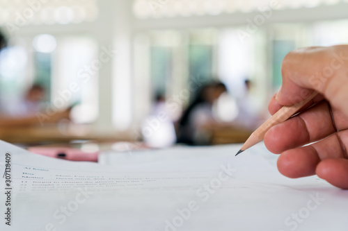 Student testing in exercise taking fill in exam at school or university in test room, document exams at campus classroom, education or back to school concept