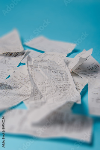 Pile of shopping receipts on blue background