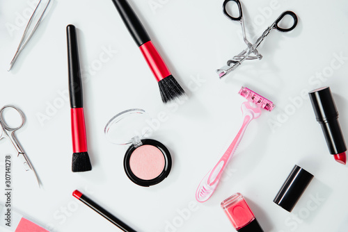 Top view on set of woman make up cosmetics on white background. Beauty and fashion concept. On table lies lipstick, eye pencil, eye shadow, brushes. Fashionable Women's Cosmetics and Accessories.