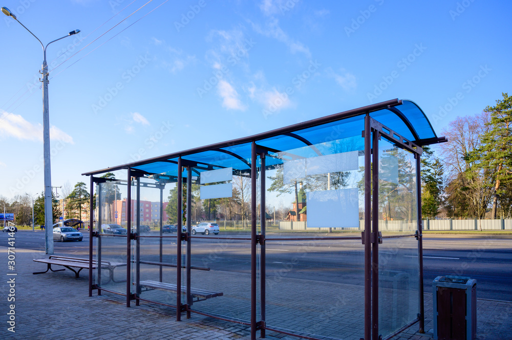 Photo of an empty public transport stop on a city street on a sunny clear day. Photo of an empty public transport stop on a city street on a sunny clear day.